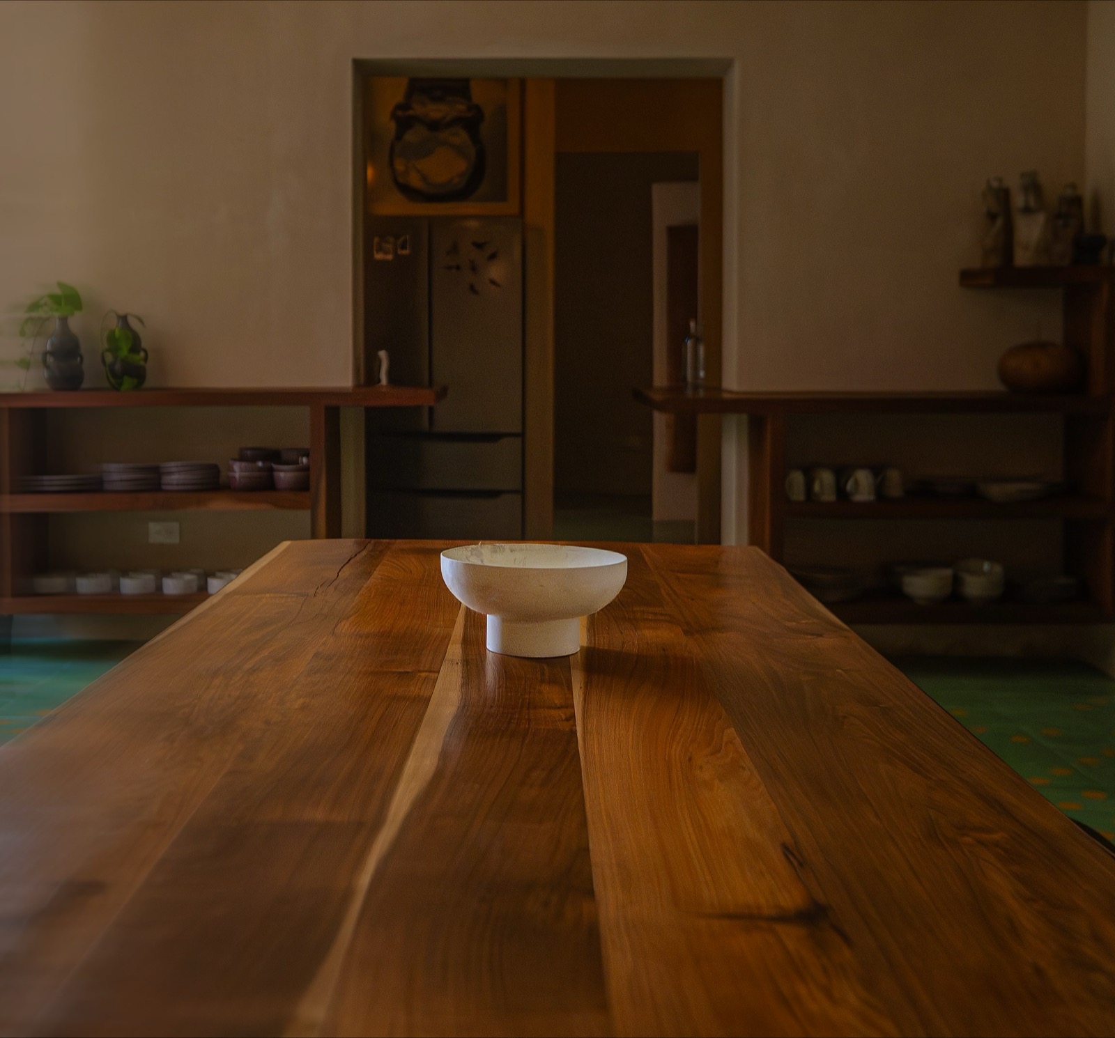 El comedor — long hardwood table, open shelves of Yucatecan ceramics