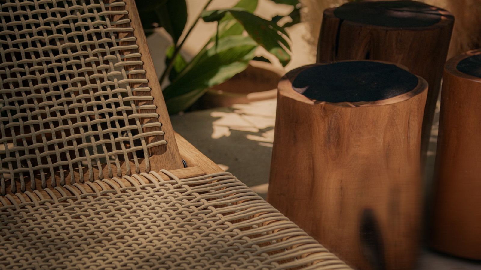 A woven chair and terracotta pots in raking afternoon light