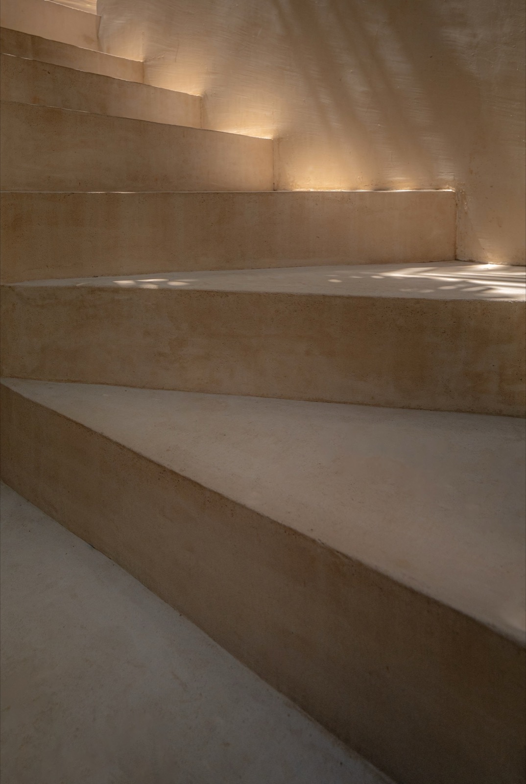 Hand-troweled plaster staircase washed in light